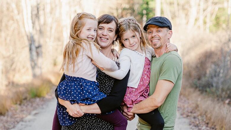 Aidan Brunn and Jennifer Laughlin stand with their two daughters. 