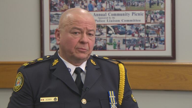 Man in police uniform sitting.