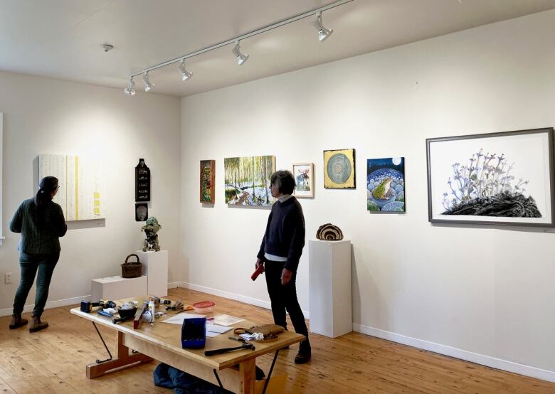 Curators installing the art piece in an open, airy art gallery. 