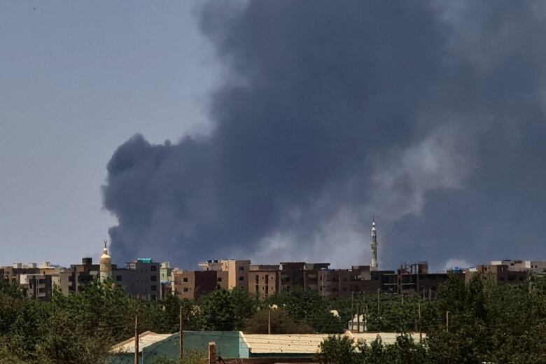 Smoke billows over buildings.