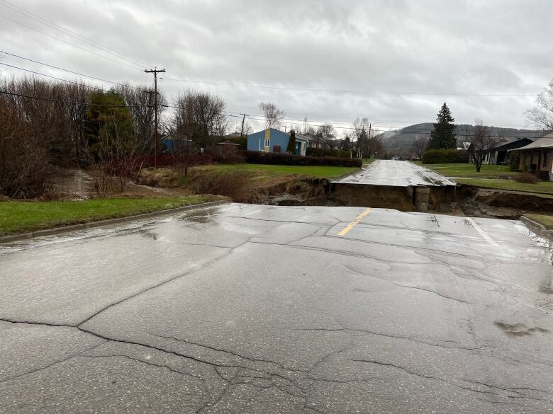 A large hole spanning the entire width of a road. 