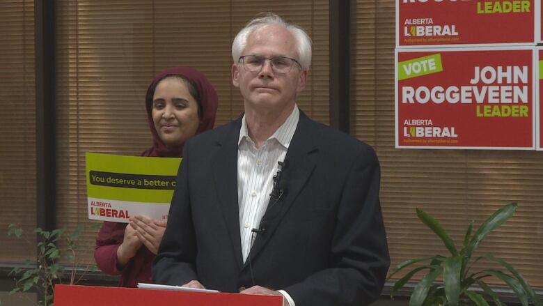 A man stands behind a podium.