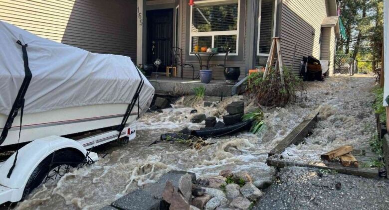 Water pours down a driveway.