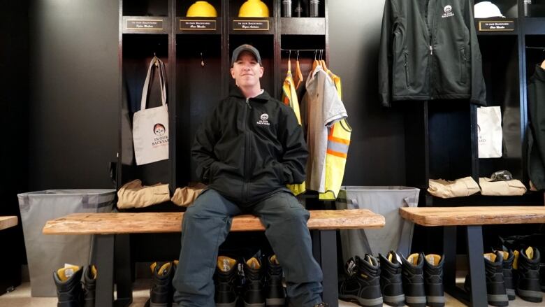 A man sitting in a space that resembles a locker room.