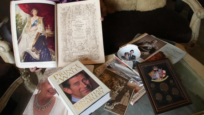 Books and other Royal Family collector's memorabilia are spread out on a table.