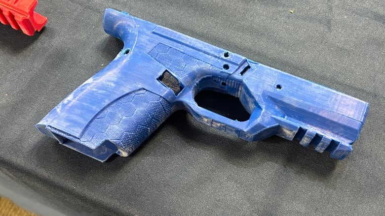 A close up of a blue 3D-printed gun handle. 