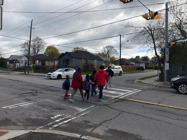 Roxanne Ashton and Shoneaca Simmons, two parents who have been fighting for a crossing guard, cross the street with their children.