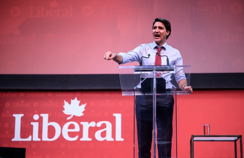 Prime Minister Justin Trudeau stands at a podium in front of a sign that reads 