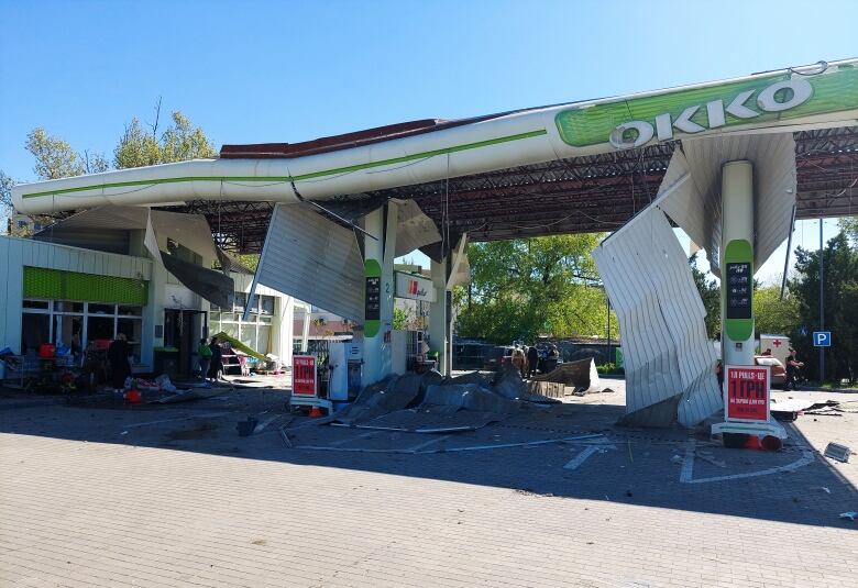 A damaged gas station and convenience store is shown.