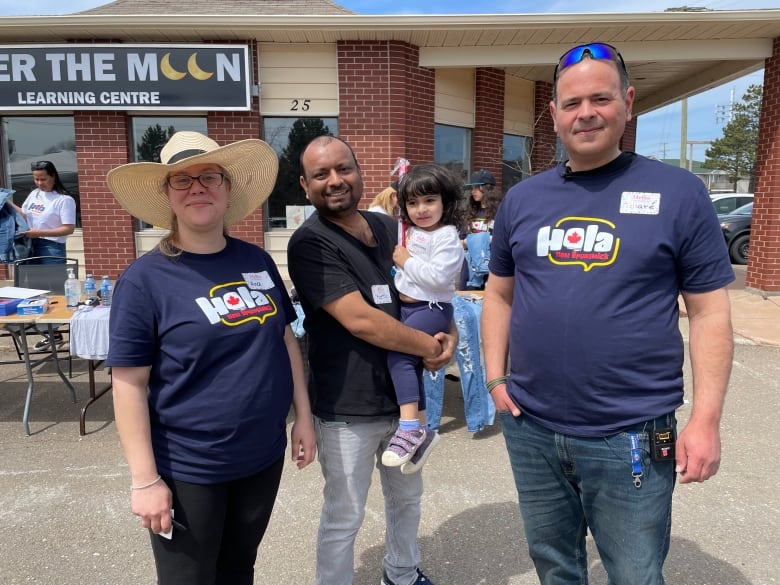 Three people and a child stand outside at a fundraiser