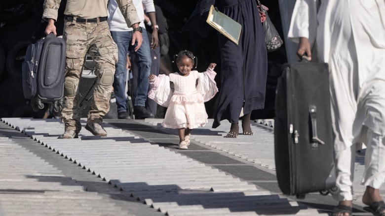 A child disembarks with her family from the USNS Brunswick at Jeddah port, Saudi Arabia, after being evacuated from Sudan on May 4, 2023.