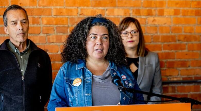 A woman stands at a podium during a news conference. 