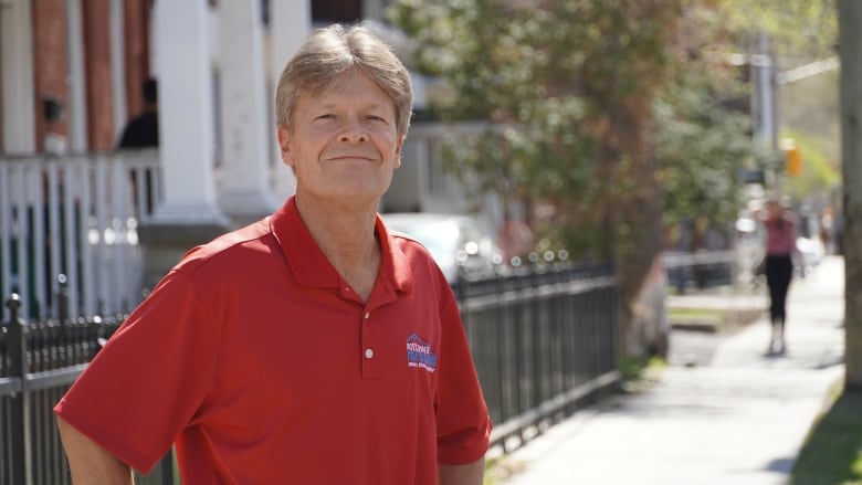 A charity executive poses for a photo outside on a warm day.