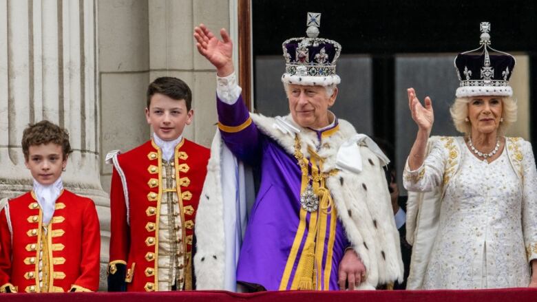 People wave from a balcony.