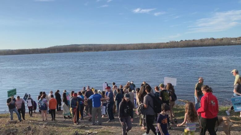 A crowd of people looking at a river