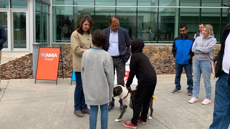 A woman and man speak to other people outside the expo centre