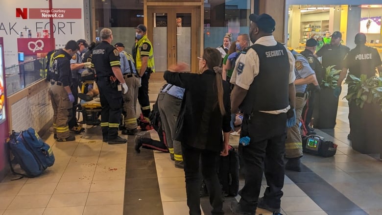 Parademics, fire crews and security guards inside a mall.