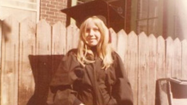 A young girl in a graduation cap and gown