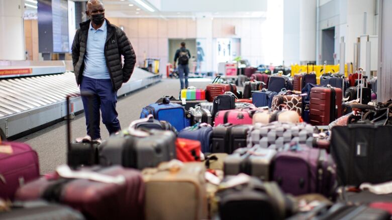 A man looks for bags at a baggage terminal.