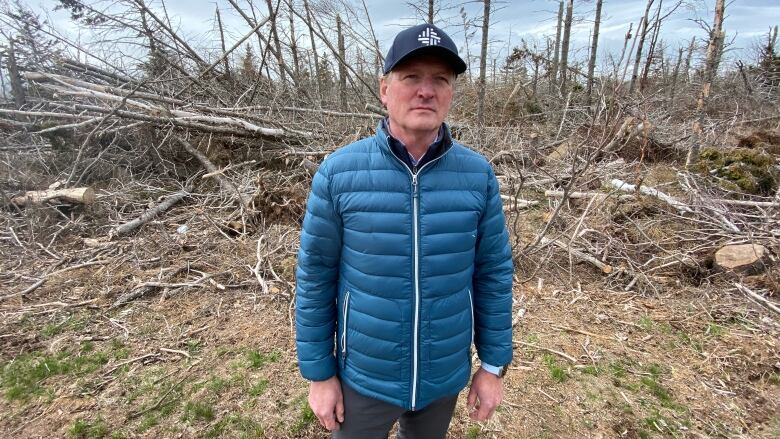 A man stands surrounded by downed trees caused by post-tropical storm Fiona. 