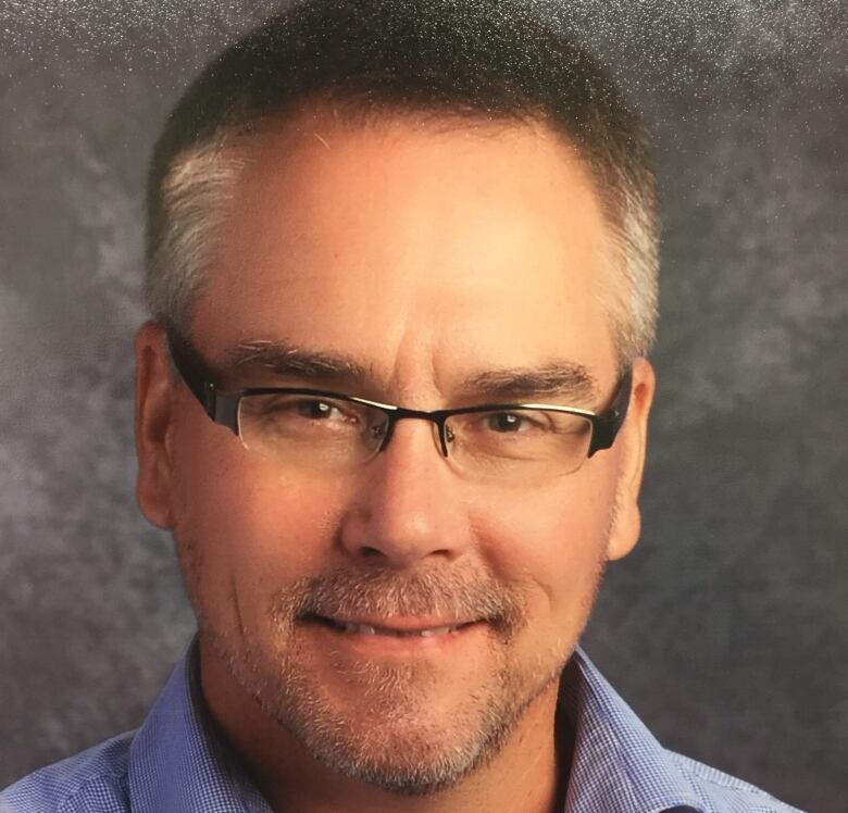 Portrait of a man in a button-up shirt.