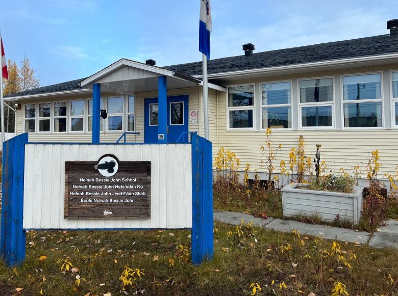 A small building will a lawn in front. A sign outside read 