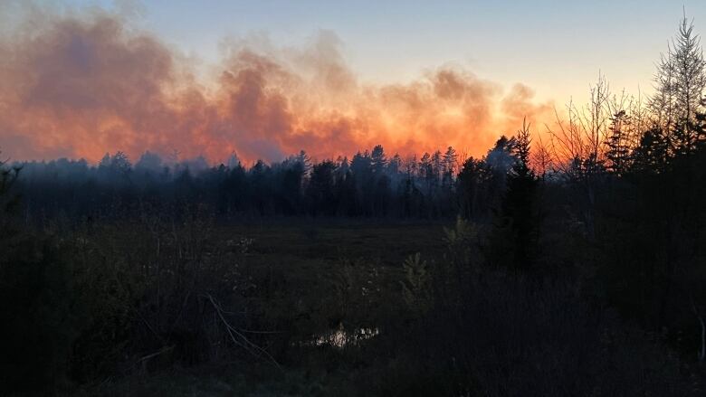 Smoke from a wildfire is shown as the sun begins to set.