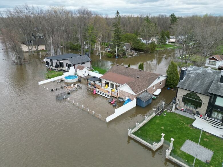 Floodwater creeps into yards and roads of a suburban waterfront area of a city. 