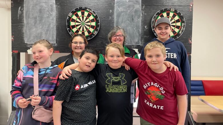 P.E.I. youth darts players pose for a photo in front of two dart boards.