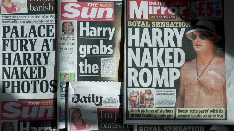 A display of several tabloid-style newspapers is shown.