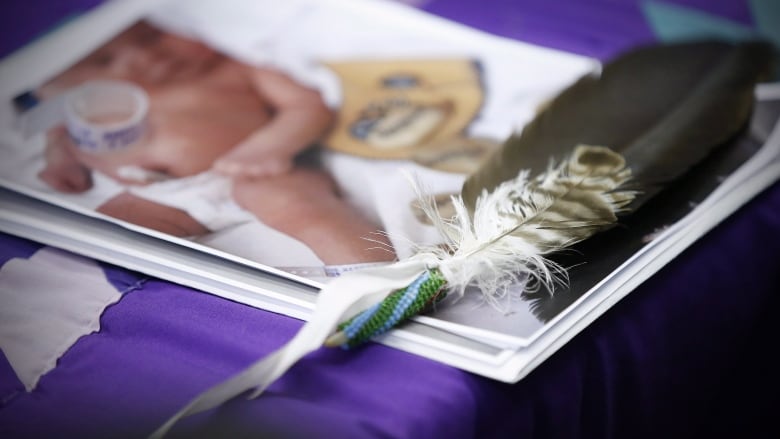 An eagle feather on a baby photo.