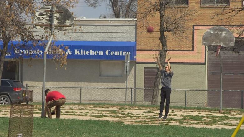 A man shoots a basketball on a court.