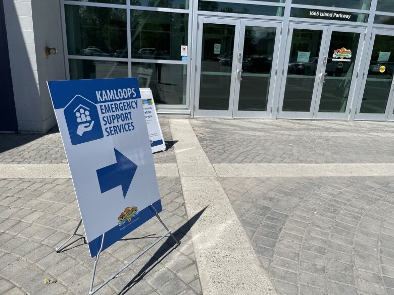 A sign reading Kamloops Emergency Support Services stands next to the entrance of a building.