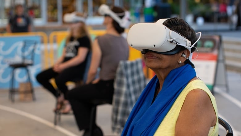 Woman sitting in chair wearing a virtual reality headset