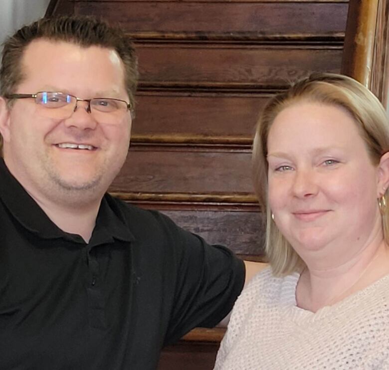 A man and woman looking into the camera, smiling. 