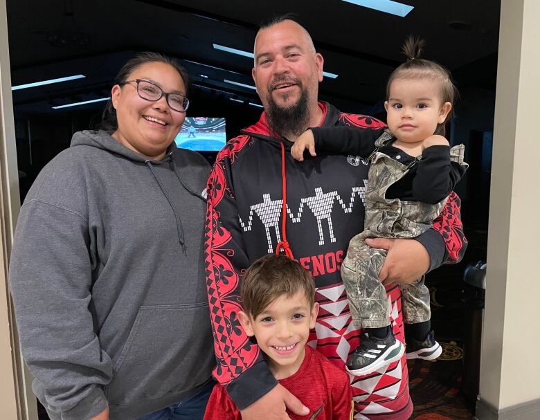 A family of four smile. 