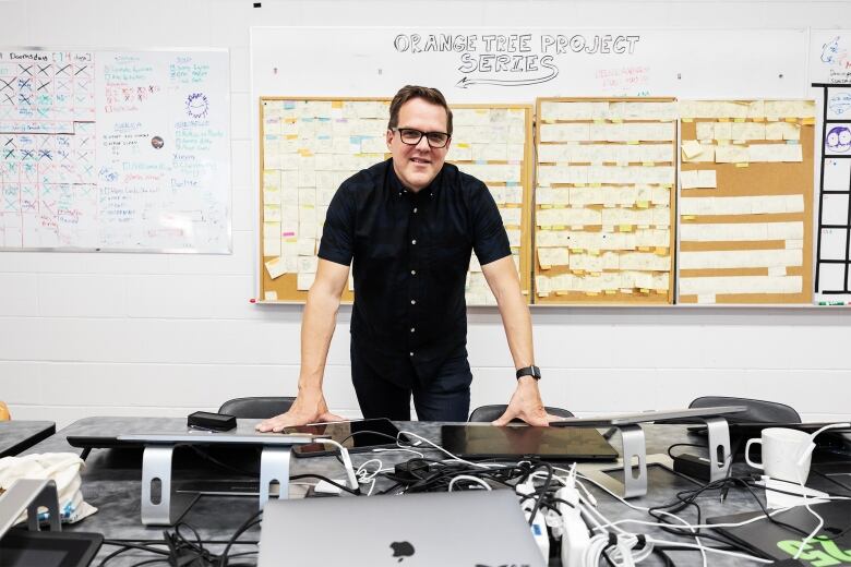 Animation teacher Jamie Leduc stands in front of his students storyboard