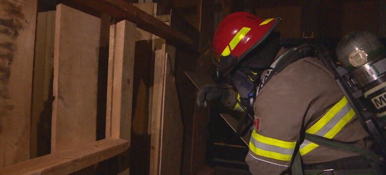 A firefighter in full uniform tries to get through a training course. 