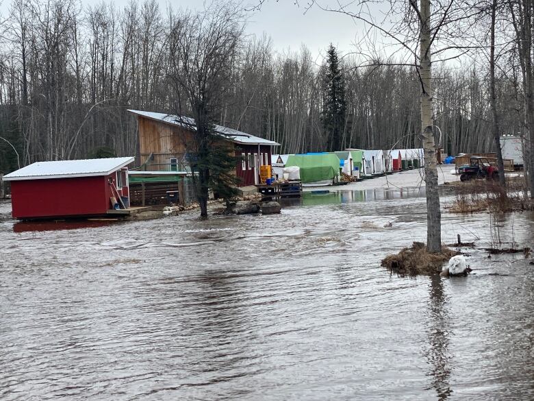 A road going into a farm completely submerged in water.