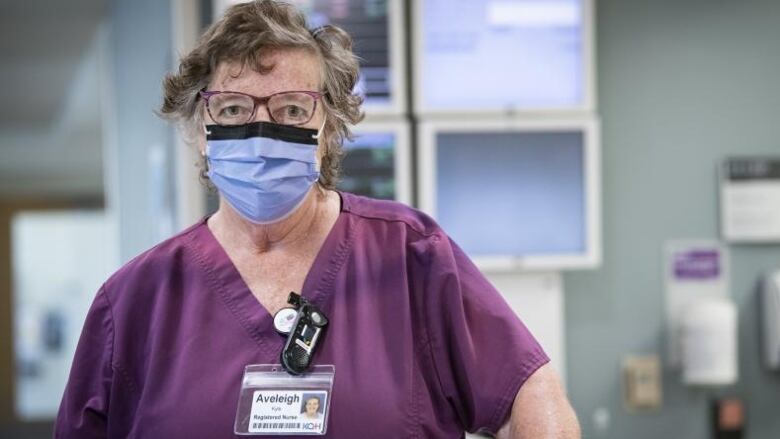 Woman in purple medical outfit with mask and goggles 