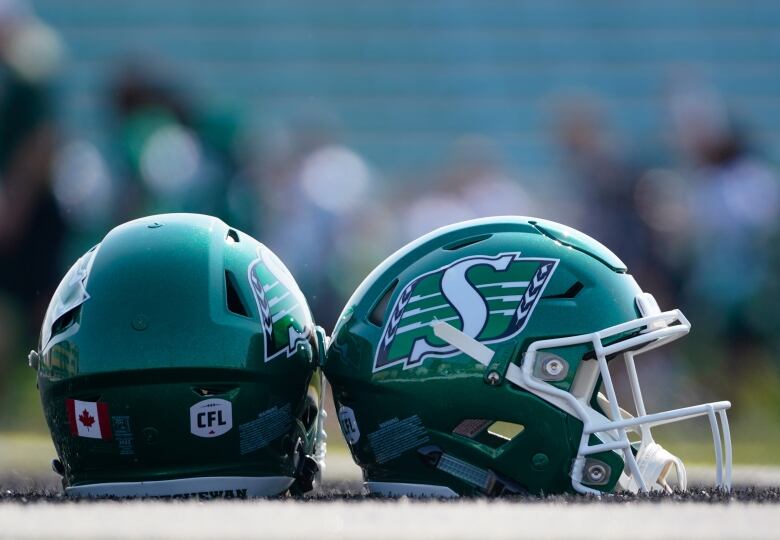 Two helmets sit on the field.