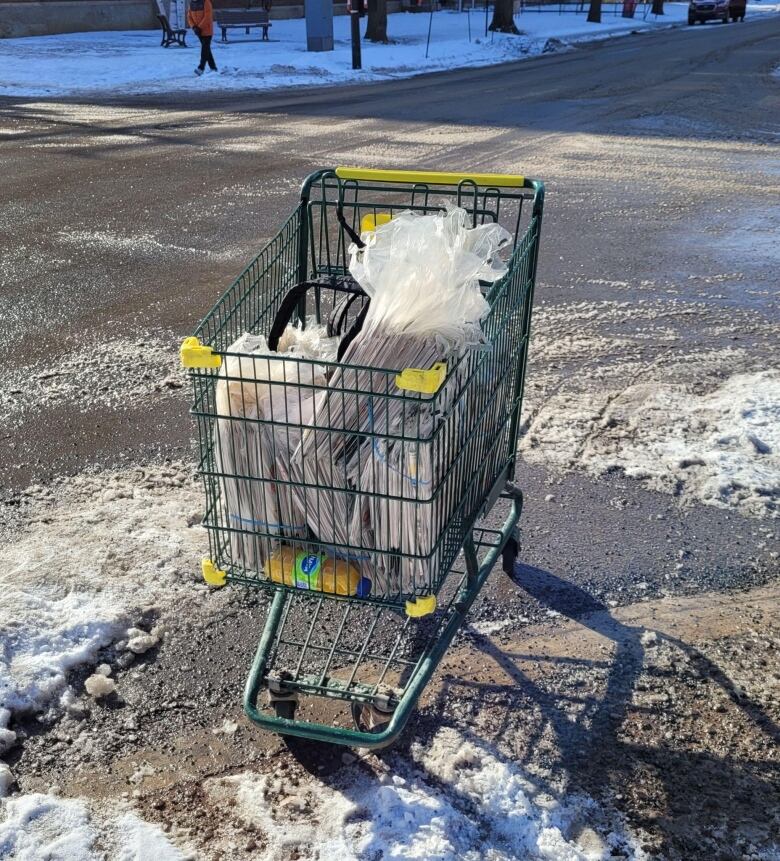 A shopping cart is full of papers.