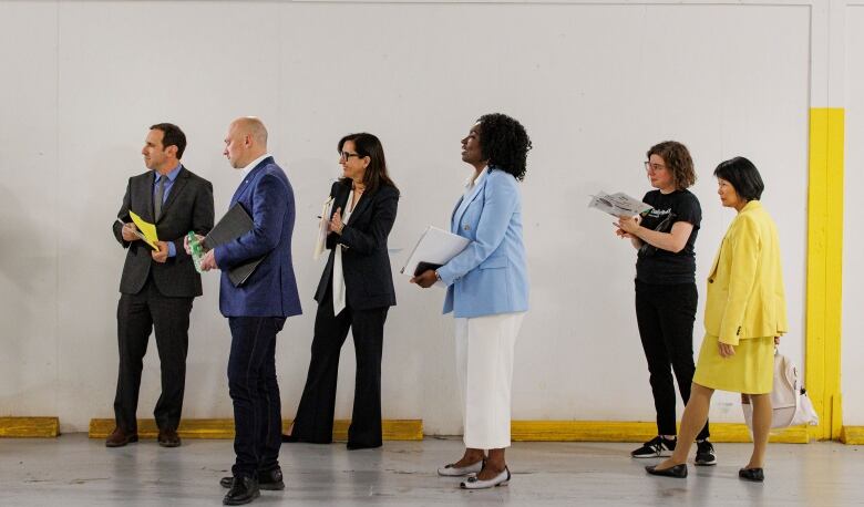 From left to right: Toronto mayoral candidates Josh Matlow, Brad Bradford, Ana Bailo, Mitzie Hunter and Olivia Chow (in yellow), wait to take the stage for a debate, held at the Daily Bread food bank, in Etobicoke, Ont., on May 15, 2023.