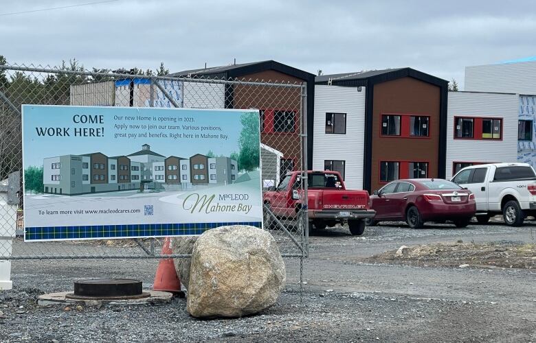 A brown and white building under construction with a sign saying, 