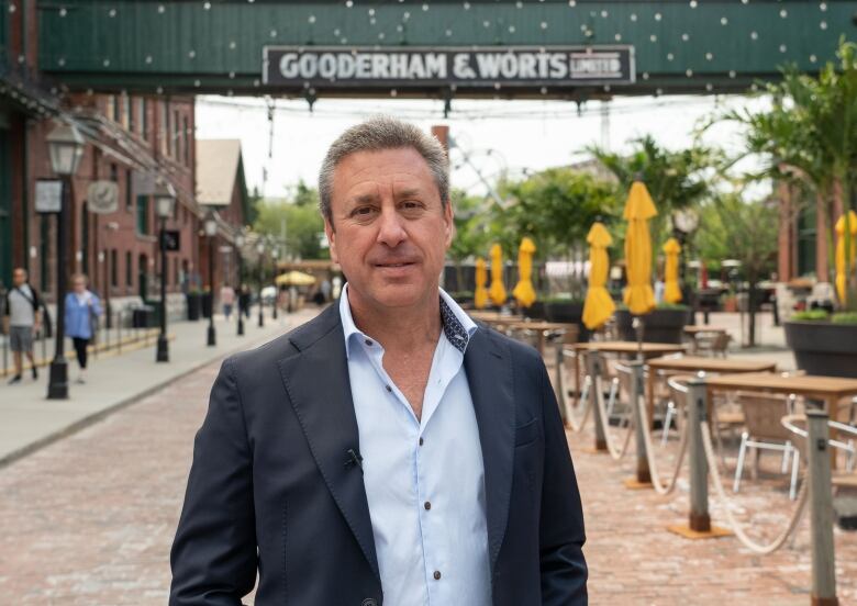 A man stands in a pedestrian-only industrial district.