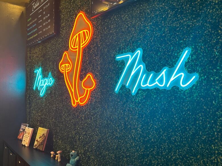 The words Magic Mush and an image of mushrooms are displayed in fluorescent lighting inside a store.