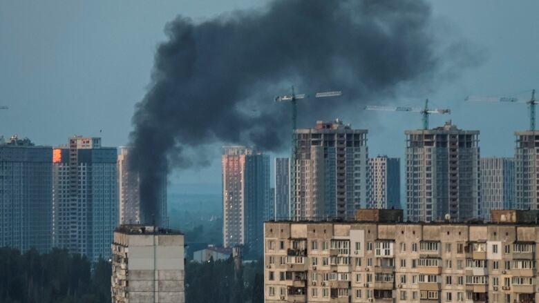 Black smoke rises from a burning building.