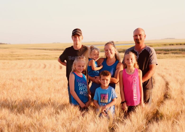 A family of seven can be seen standing in a farm field in Saskatchewan. 