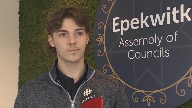 Young man standing in front of wall in the epekwitk assembly of councils offices