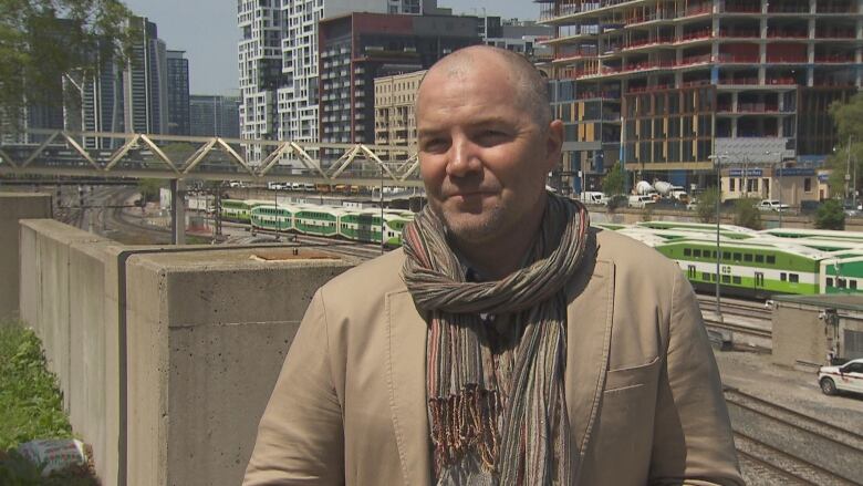 Photo of Drew Sinclair standing above the rail corridor.  